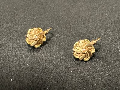 une paire de boucles d'oreilles en or sur une surface noire