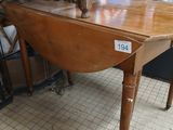 a wooden table with two chairs on it in a room