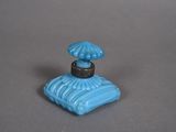 a small blue perfume bottle with an umbrella on top of it