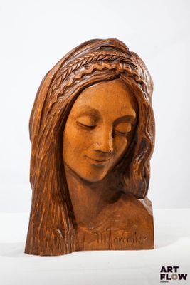 sculpture représentant la tête d'une femme aux cheveux longs et tressés