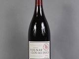 a bottle of red wine sitting on top of a glass table