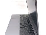 a silver laptop with a black keyboard on a white surface