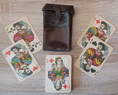 quatre cartes à jouer et un portefeuille posés sur une table en bois