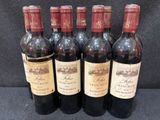 six bouteilles de vin sont alignées sur une table