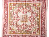 a pink and gold square scarf with a floral design on it