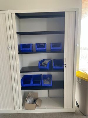 an open cupboard with bins and bins in it