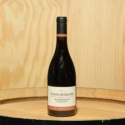 a bottle of wine sitting on top of a barrel