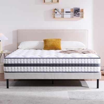a white bed sitting on top of a wooden floor next to a white wall