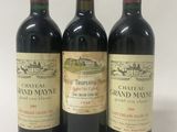 three bottles of red wine sitting on top of a white table