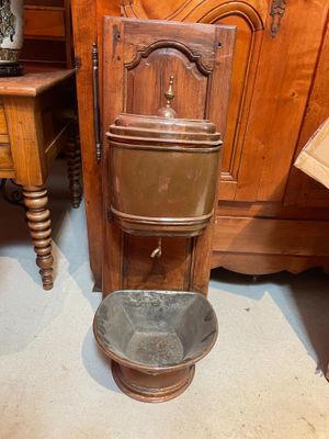 a toilet that is sitting next to a wooden cabinet