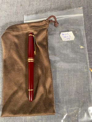 un stylo rouge posé sur un sac marron