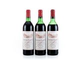 three bottles of red wine sitting next to each other on a white surface