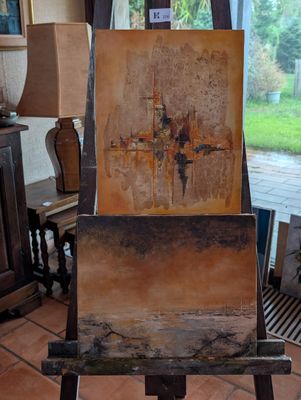 un chevalet sur lequel est posé un tableau, dans un salon