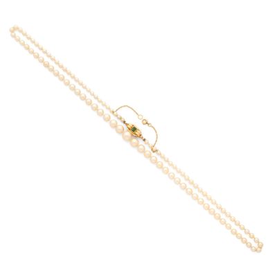 un gros plan sur un collier de perles muni d'un fermoir en or