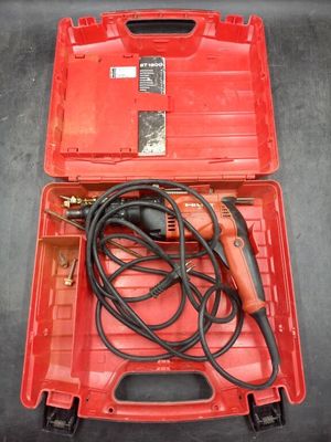 an electric drill in a red case with a cord in it
