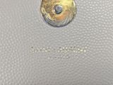the inside of a white purse with a gold button on it