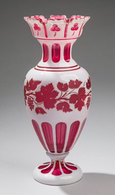 un vase rose et blanc posé sur une surface blanche