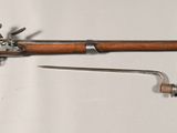 a wooden rifle mounted on a wall with a wren