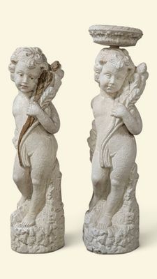 deux statues d'anges tenant une coupe au-dessus de leur tête