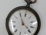 a black pocket watch with roman numerals on the face