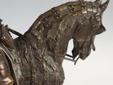 bronze statue of a man on a horse with a helmet on