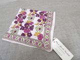 a purple and yellow flowered handkerchief with a tag on it