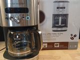a coffee maker sitting on a table next to a box of coffee
