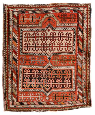 un tapis ancien à motifs géométriques sur fond blanc