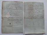 two old papers with writing on them sitting on a table