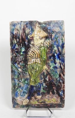 une petite sculpture en céramique représentant un poisson, posée sur un socle