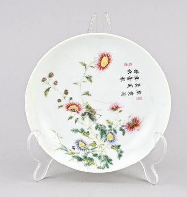 une assiette blanche décorée de fleurs, posée sur un support