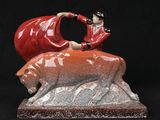 figurine of a woman sitting on top of a red bear
