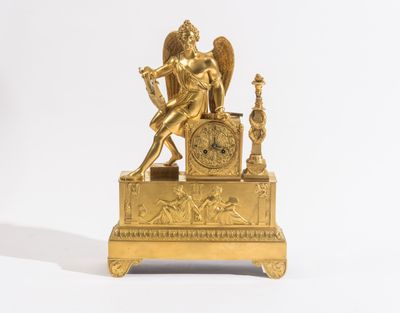 statue dorée représentant un ange tenant une horloge, sur fond blanc