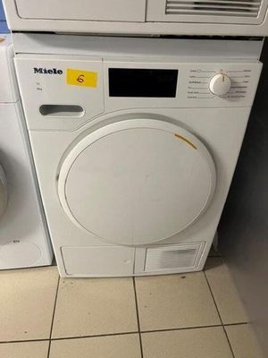two washers and a dryer in a small room