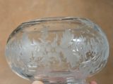 a person holding a glass vase with a design on it