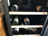 many bottles of wine in a wine cooler in the kitchen
