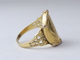 a close up of a gold ring on a white surface