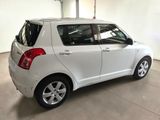 the rear end of a small white car in a garage