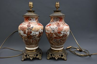 une paire de vases asiatiques ornés de scènes asiatiques, posés sur une table