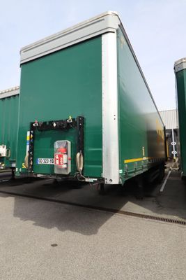 deux semi-remorques verts garés côte à côte sur un parking