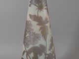 a glass vase with a brown and white design on it