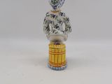 porcelain figurine of a woman sitting on top of a barrel
