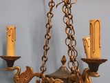 a gold chandelier with three candles hanging from it