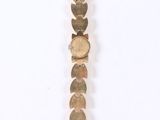 a close up of a gold bracelet with hearts on it