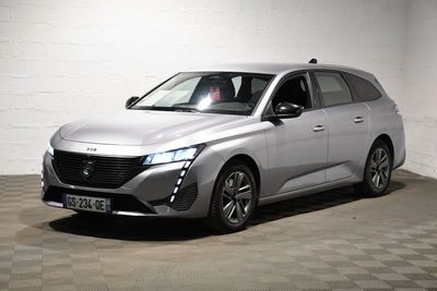 La voiture argentée est garée sur le sol à damier du garage.