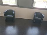 two black chairs in the corner of a room