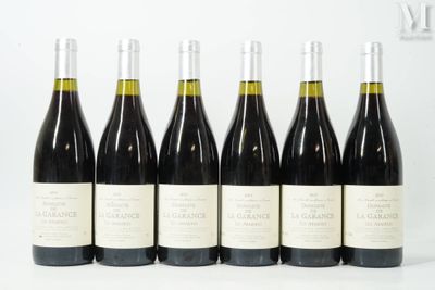 six bouteilles de vin sont alignées sur une surface blanche
