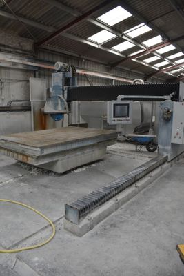 a large machine that is cutting a piece of wood in a building