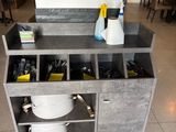 une cuisine équipée d'un évier et d'un plan de travail sur lequel sont posés de nombreux ustensiles