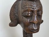 an image of a wooden sculpture of a woman ' s head on a table